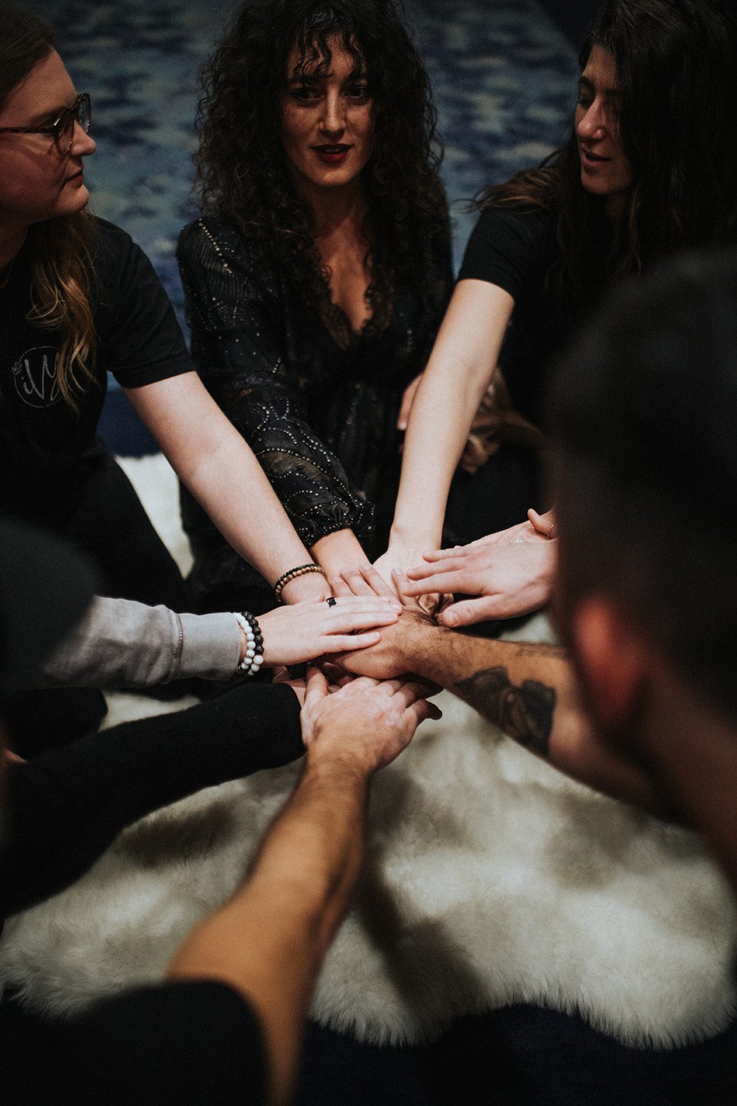 Hands stacked together in a circle at a past gathering