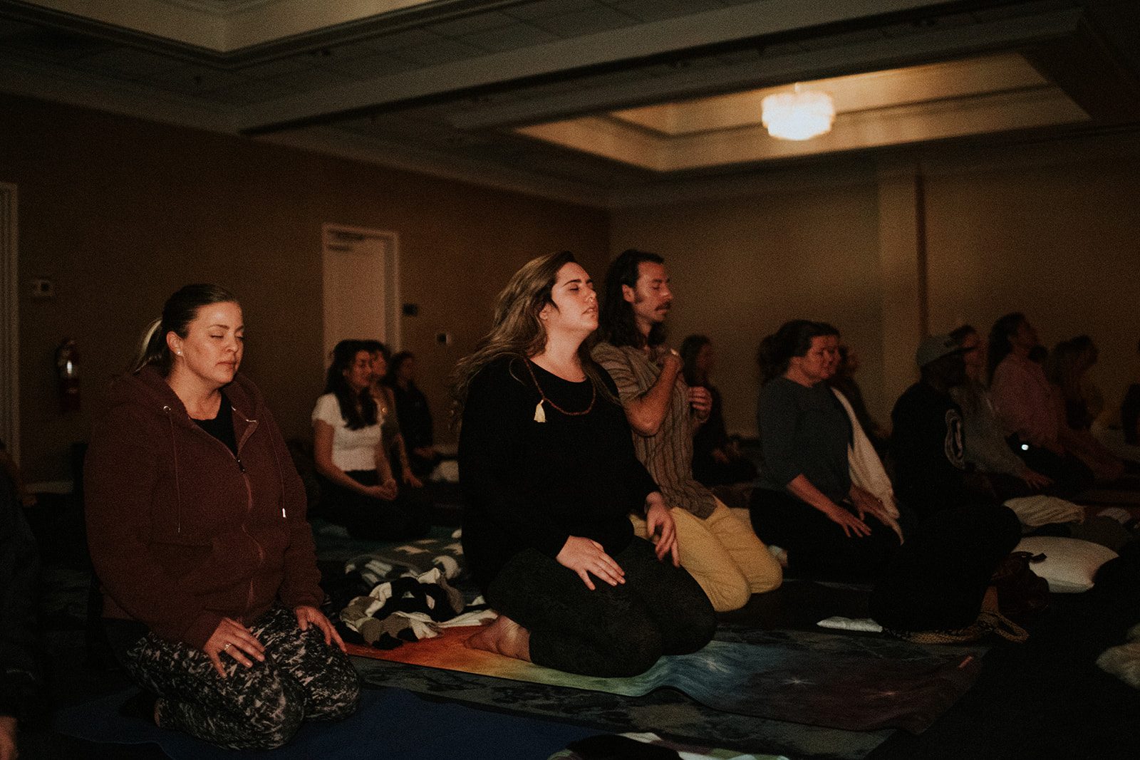 Group meditating together with eyes closed during a past gathering
