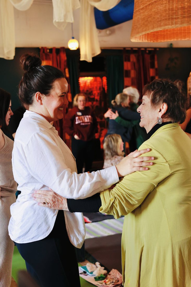Two women greeting each other warmly during a past gathering